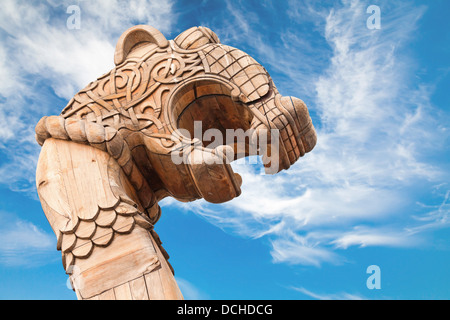 Carved wooden dragon on the bow of Viking ship above dramatic blue sky Stock Photo