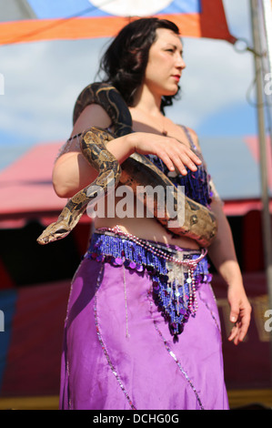 A snake charmer woman at a carnival act at the Steele County Fair in Minnesota. Stock Photo