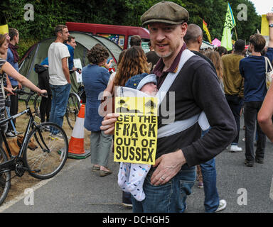 Balcombe, West Sussex, UK. 18th Aug, 2013. Balcombe, West Sussex, UK. 18th Aug, 2013. Local environmentalist against fracking in Sussex joins the back of the parade on the road to Cuadrilla site whilst his son sleeps soundly. © David Burr/Alamy Live News Stock Photo