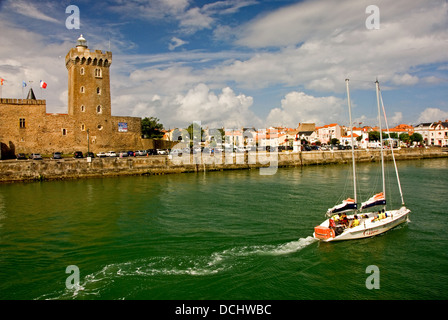 Sailing boat entering the French port of Les Sables D'Olonne in the Vendee region, passes Arundel Tower and the remains of La Chaume castle. Stock Photo