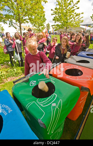 School children at the Hay festival putting waste containers in a bin for recycling. Stock Photo