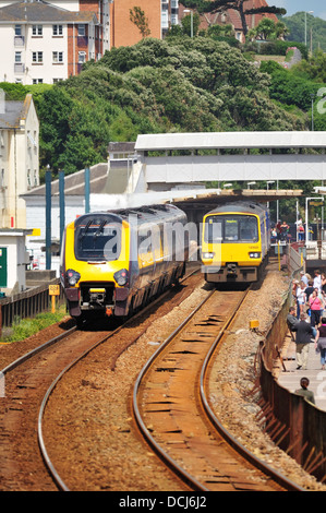 A crosscountry express passenger train passes a First Great Western local regional train at Dawlish Station in Devon Stock Photo