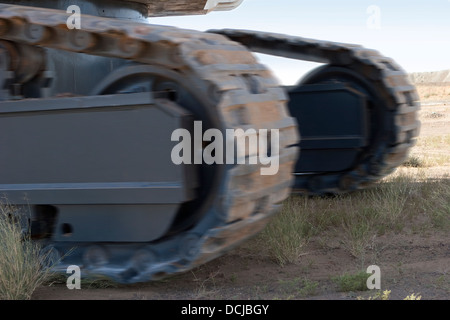 Close up of tracks of giant hydraulic excavator digger moving to new working position, gold mining site in Mauritania, NW Africa Stock Photo