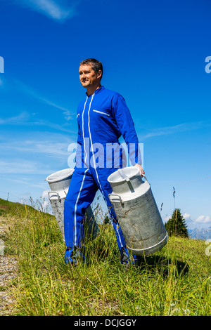 Herdsman standing in front of cattle in farm Stock Photo