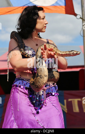 A snake charmer woman at a carnival act at the Steele County Fair in Minnesota. Stock Photo