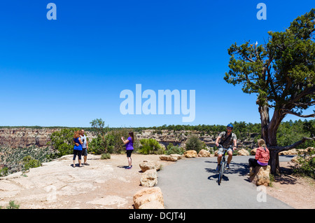 Cyclist and tourists on East Rim Trail between Mather Point and Yaki Point, South Rim, Grand Canyon National Park, Arizona, USA Stock Photo