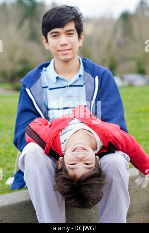 Big brother taking care of disabled little brother Stock Photo