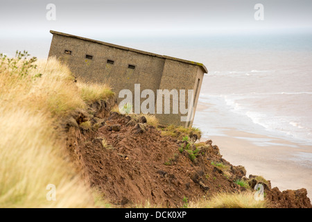 A Second world War lookout post leaning alarmingly and about to tumble over the edge of the cliff near Aldbrough Stock Photo