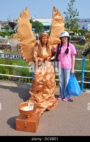 holiday maker with human statue dressed as an angel, Skegness, Lincolnshire, England, UK Stock Photo