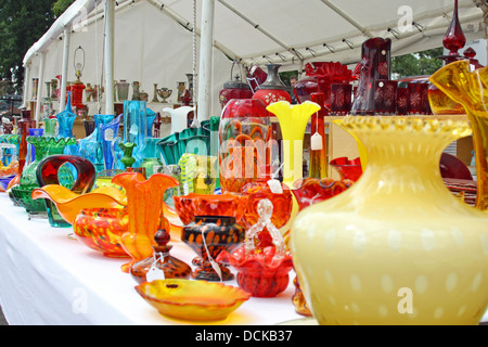 Beautiful blue and colorful vintage glassware displayed on a table at an Antique Flea Market, Oronoco Gold Rush Days. Stock Photo