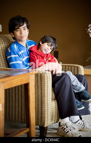 Big brother taking care of disabled sibling with cerebral palsy Stock Photo