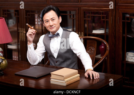 Wealthy businessman smoking cigar Stock Photo