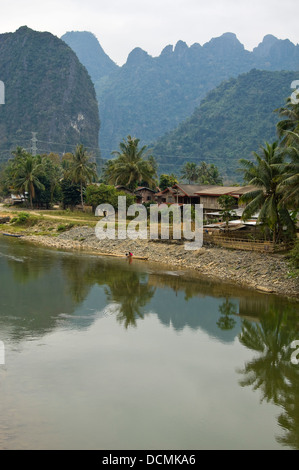 Vertical aerial view of ramshackled wooden huts and homes along the banks of the Nam Song river close to Vang Vieng Stock Photo