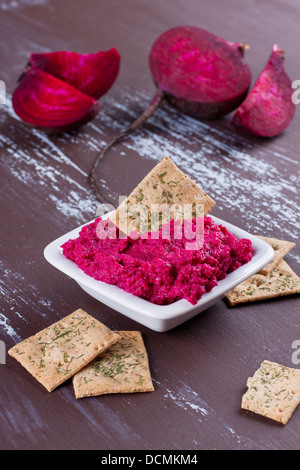 Portion of beetroot hummus with cut beetroot on background Stock Photo