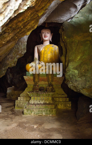 Vertical close up of the large Buddha statue guarding the entrance of Tham Hoi, Shell Cave in Vang Vieng Stock Photo