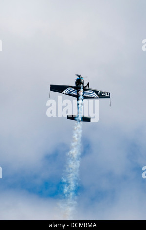 Vertical view of an aircraft with a vapour trail doing stunts during an air display. Stock Photo