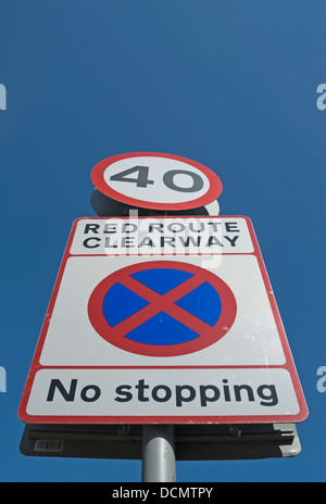 british red route clearway road sign with no stopping image and 40mph speed limit sign Stock Photo