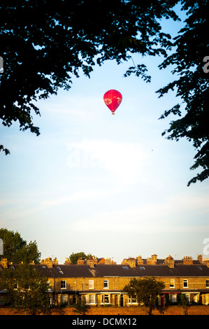 KitKat Hot air balloon framed by trees and flying over houses Stock Photo