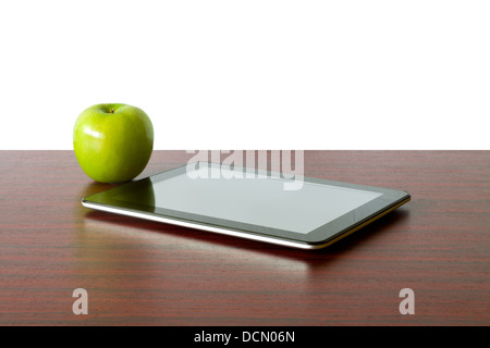 Digital tablet and apple on the desk in front of blackboard Stock Photo
