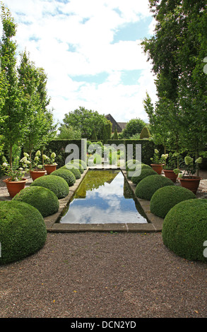 The pond and topiary at the Upper Rill Garden at Wollerton Old Hall Gardens garden Wollerton Market Drayton Shropshire England UK Stock Photo