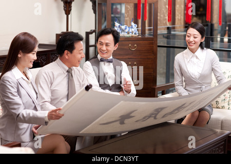 Business people admiring calligraphy and painting Stock Photo