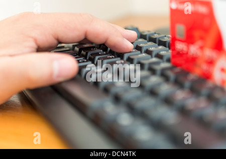 Male hands entering credit card information into a computer Stock Photo