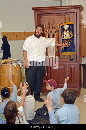 Young children get a lesson in how Torahs are made at the Jewish Children's Museum in Crown Heights, Brooklyn, New York Stock Photo