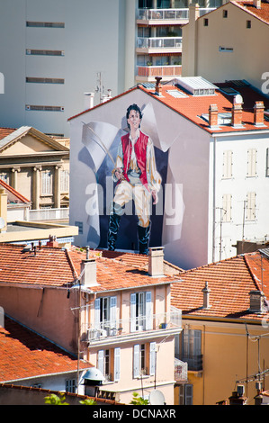 A huge poster with the image of a young man in medieval clothes on the wall,  French Riviera, France. Stock Photo