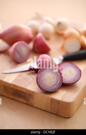 Assortment of Onions and Shallots on cutting board Stock Photo