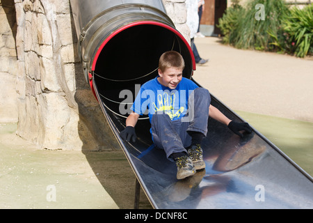 A boy going down a slide. Stock Photo