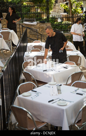 San Antonio, Texas - A waiter sets tables for dinner in a restaurant on the Riverwalk. Stock Photo