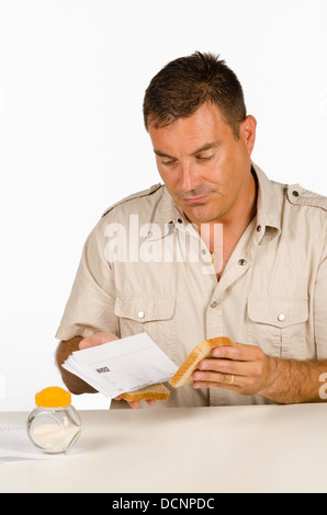 Guy setting up a sandwich stuffed with bills, a financial concept Stock Photo