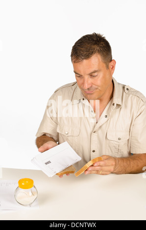 Guy setting up a sandwich stuffed with bills, a financial concept Stock Photo