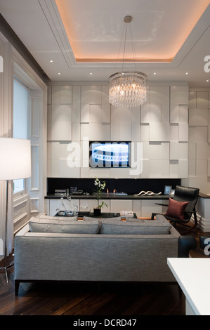 Seating area with glass chandelier and recessed fire in London city apartment Stock Photo