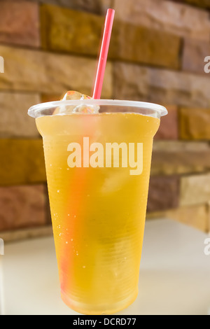 A glass filled to the top with ice tea and ice cubes. Stock Photo