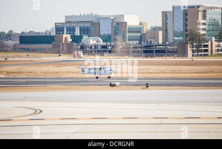 A single engine Cessna 172 propeller airplane on the runway of a small regional airport Stock Photo