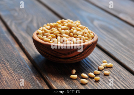 pine nuts in wooden bowl on wooden background Stock Photo