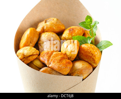 Peeled roasted chestnuts in a paper cone Stock Photo