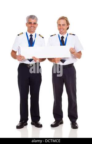 smiling airline pilots holding blank banner on white background Stock Photo