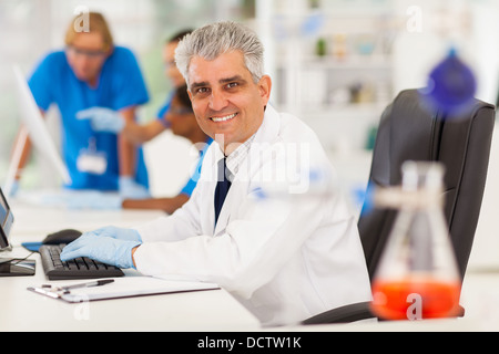 cheerful senior lab technician working on computer Stock Photo
