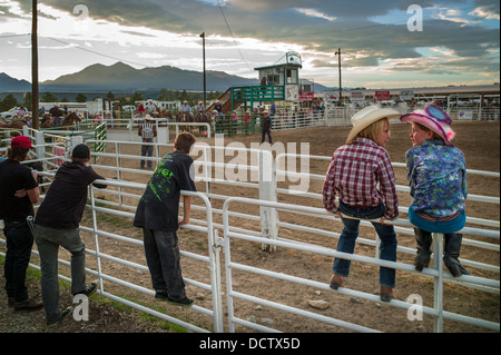 Young boy & girl perched on corral fence watch the Chaffee County Rodeo Stock Photo