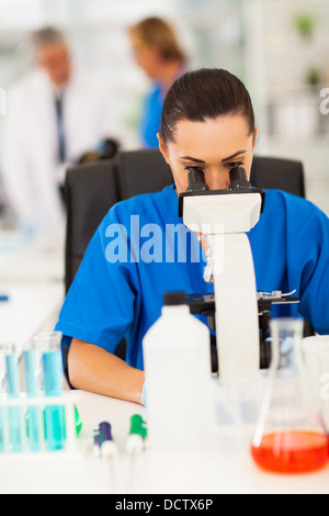 smart female scientist using microscope in laboratory Stock Photo