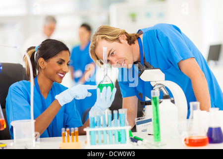 two cheerful scientists studying substances in laboratory Stock Photo