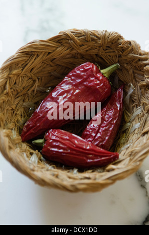 Red chilli peppers in a woven basket Stock Photo