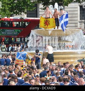Scottish football fans climb top of Trafalgar Square fountain people stop off in London before match between England Scotland team Wembley England UK Stock Photo