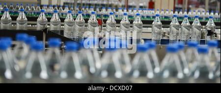 Bottles are pictured on the production line in the bottling plant of the Coca-Cola Erfrischungsgetränke AG production facility in Genshagen, Germany, 21 August 2013. Here, Coca-Cola products are filled into disposable packaging on 158,000 square meters. 170 employees work in the production facility, which was opened in 1998. The Coca-Cola Erfrischungsgetränke AG is one of the biggest beverage companies in Germany with a sales volume of 3.7 billion liters in 2012. Photo: Jens Kalaene Stock Photo