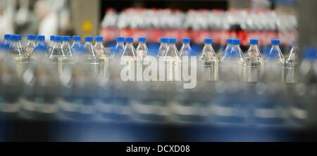 Bottles are pictured on the production line in the bottling plant of the Coca-Cola Erfrischungsgetränke AG production facility in Genshagen, Germany, 21 August 2013. Here, Coca-Cola products are filled into disposable packaging on 158,000 square meters. 170 employees work in the production facility, which was opened in 1998. The Coca-Cola Erfrischungsgetränke AG is one of the biggest beverage companies in Germany with a sales volume of 3.7 billion liters in 2012. Photo: Jens Kalaene Stock Photo