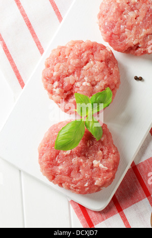 Raw meat patties on a cutting board Stock Photo