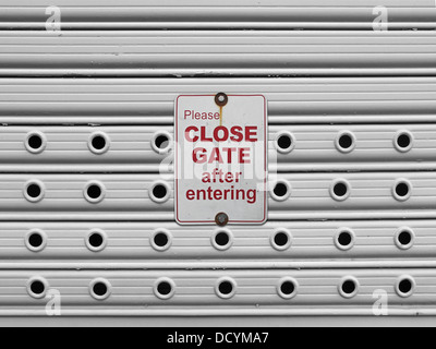 please close sign on a light grey painted perforated roll up gates background Stock Photo