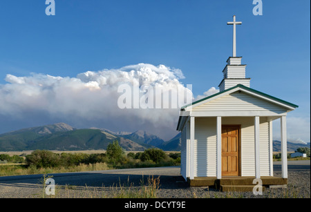 The Emigrant Fire fire storm forest fire burns on Emigrant Peak behind the Chapel at Emigrant, Montana in Paradise Valley Stock Photo